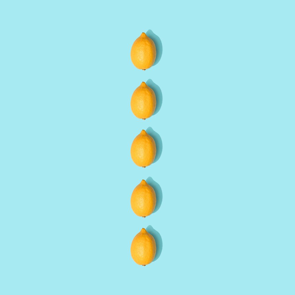 Row of lemons on pastel blue background