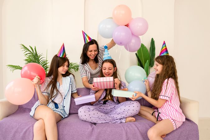 Joyful birthday celebration with family opening gifts at home.