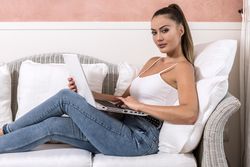 Woman using computer and sitting on couch
