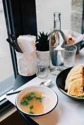 Table setting with water, pita bread consommé and dip