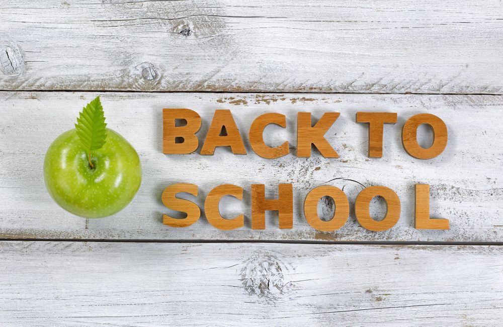 Back to school letters with apple on top of old desk