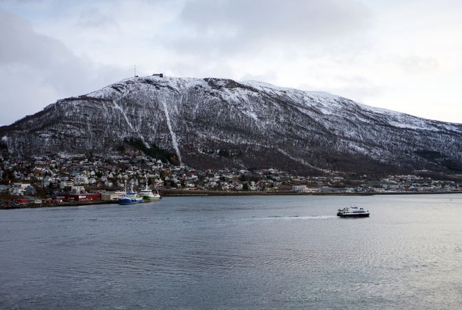 Landscape of sea bay next to big snowy cliff