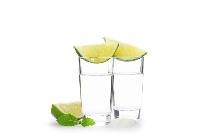 Tequila shots, lime, mint and salt isolated on blank background