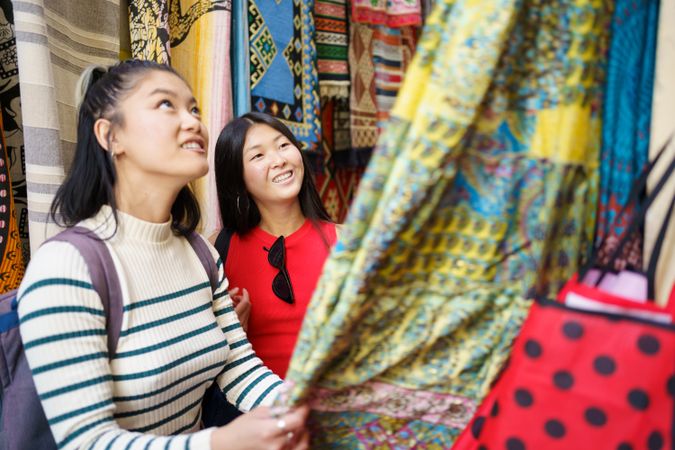 Female tourists buying clothes from street market