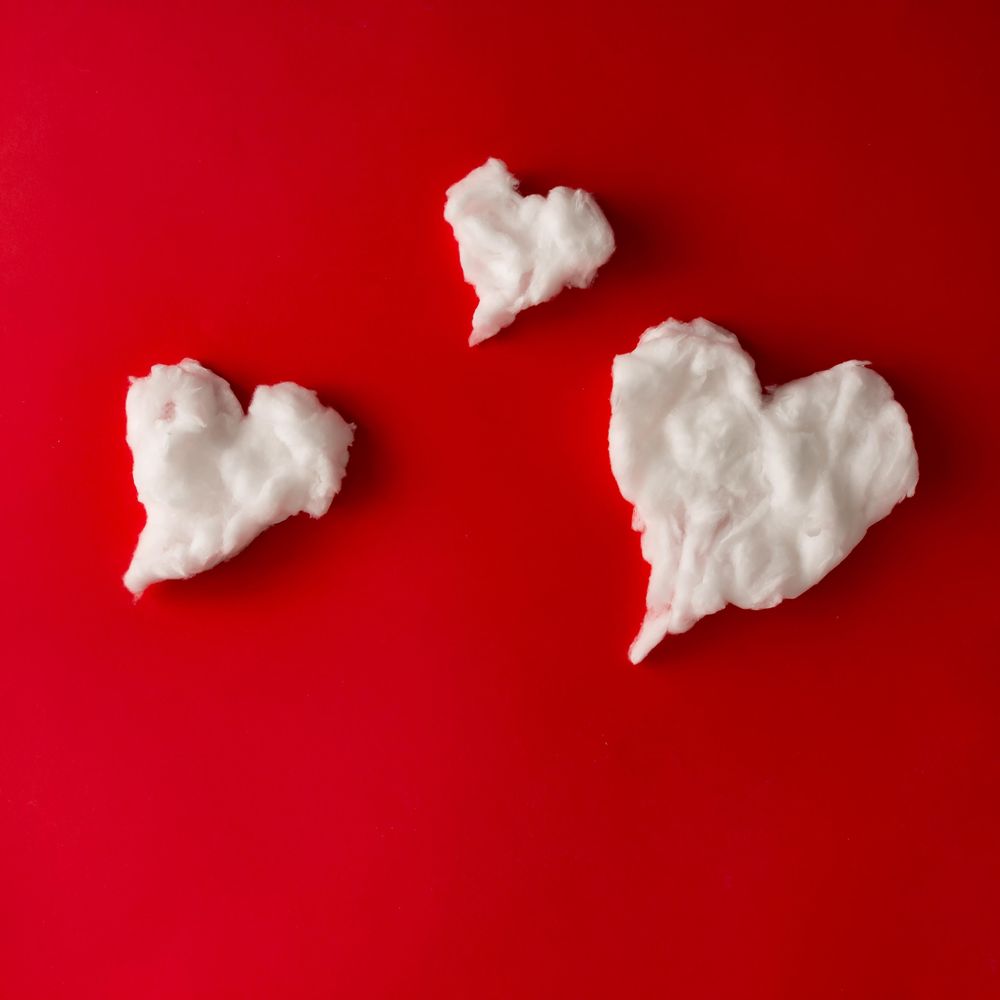 Heart shape fluffy clouds on red background
