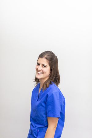 A female dentist smiling in her scrubs