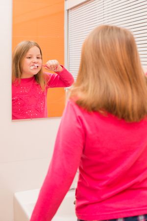 Cute girl brushing her teeth