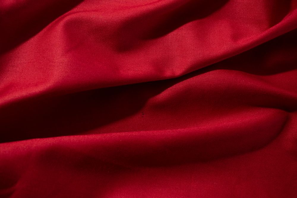 Close up crumpled wavy Red silky fabric background texture.