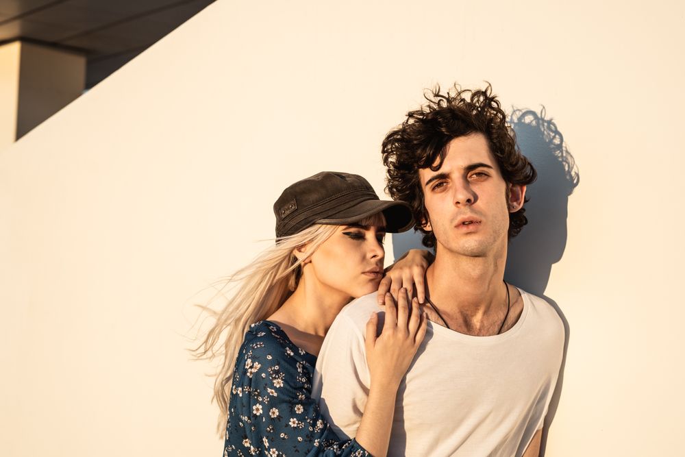 Couple leaning on wall contemplating