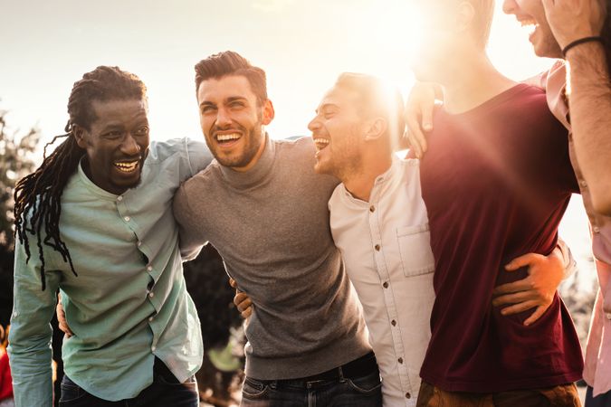 Joyful male friends bonding on sunny day