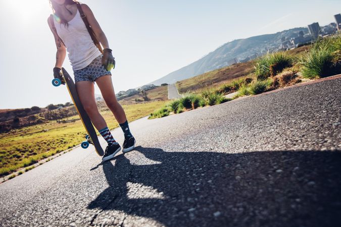 Cropped shot of young woman walking with her skateboard