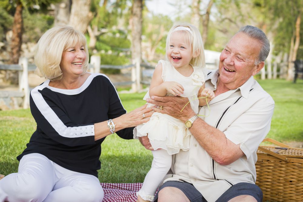 Affectionate Granddaughter and Grandparents Playing At The Park