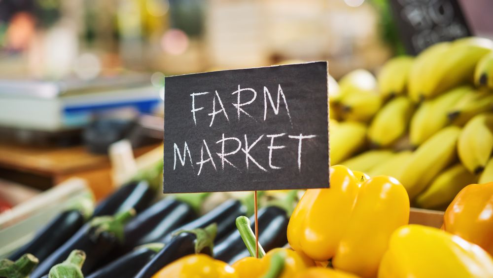 Farm Market Sign on a Food Stall with a Selection of Fresh Organic Fruits and Vegetables from a Local Farmland.