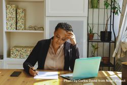 Female business owner concentrating on paper work in her home office bGk3Vb