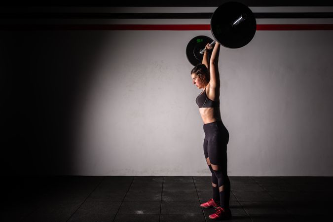 Woman lifting barbell in gym