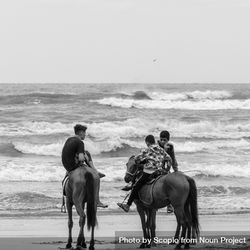 Grayscale photo of teenage boys riding horses on beach 0VyyNb