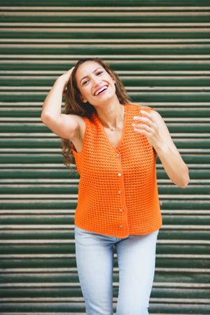 Cute woman arranging her long hair smiling at camera