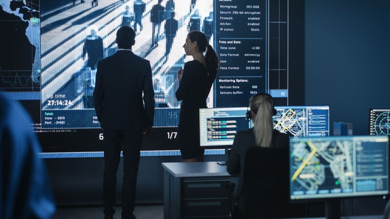 Executives Analyze Financial Data on Large Screen in High-tech Operations Room.