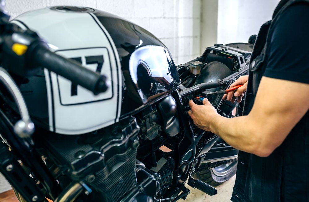 Motorcycle mechanic changing a fuse