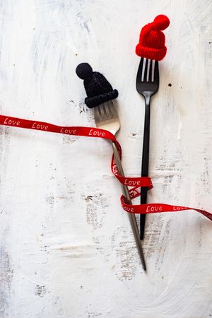 Cutlery with woolen hats and ribbon
