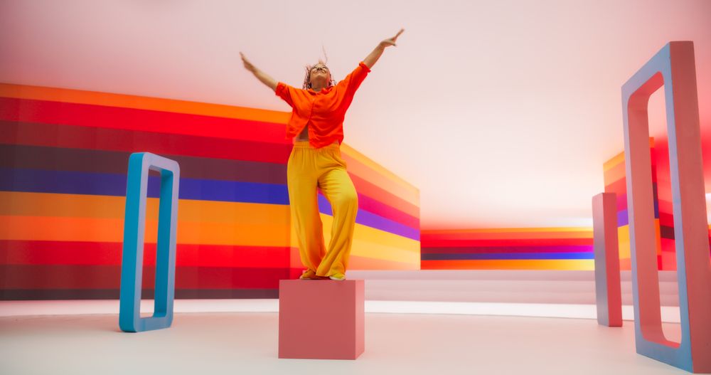 Portrait of a Talented Black Female Artist Showcasing Dance Movements in Abstract Colorful Studio Decoration.