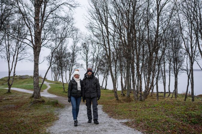 Couple walking on park path near sea