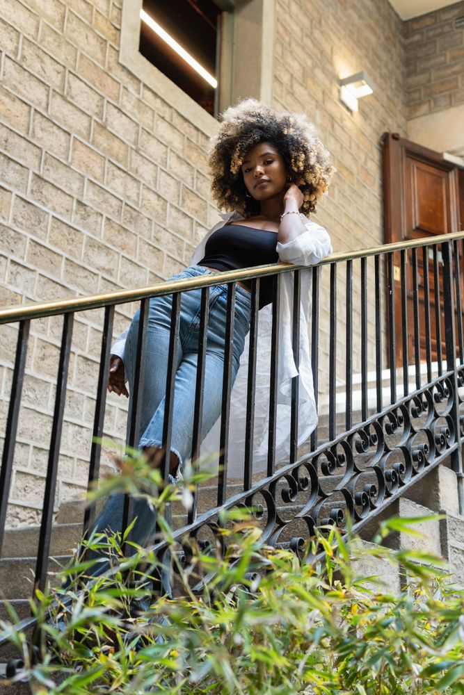 Black woman standing near railing of stairway