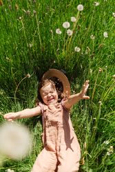 Happy little girl lying on grass