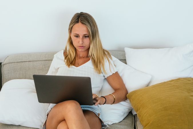 Woman browsing laptop on couch