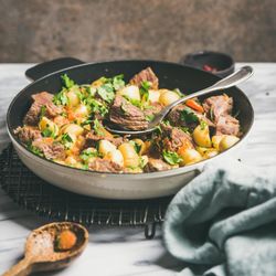 Braised beef stew with potatoes, carrots and parsley, square crop, copy space