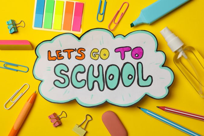 Text Let's go to school and school supplies on yellow background