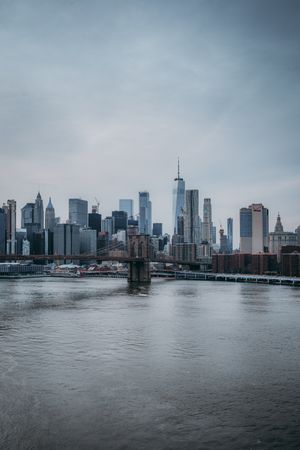 Brooklyn bridge near cityscape of NYC under cloudy sky