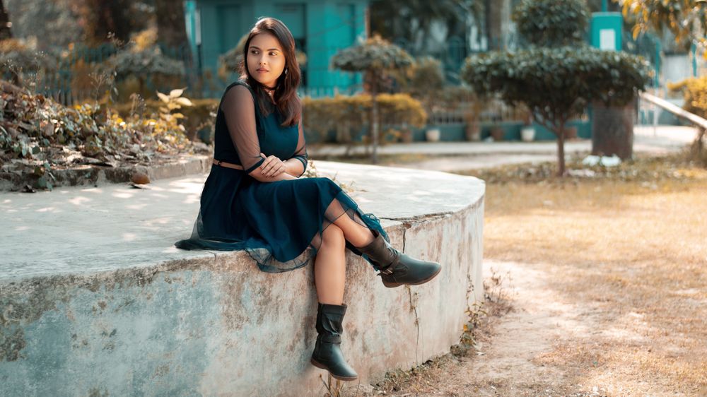 Woman in dress sitting on concrete bench outdoor