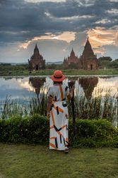 Woman standing at lakeside and enjoying view of Buddhist temples
