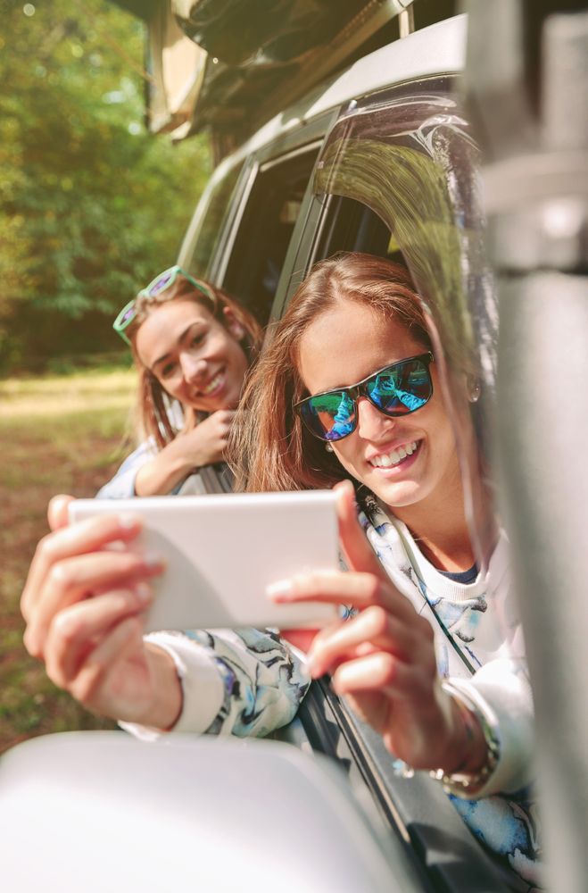 Woman taking photo to her friend through the window car