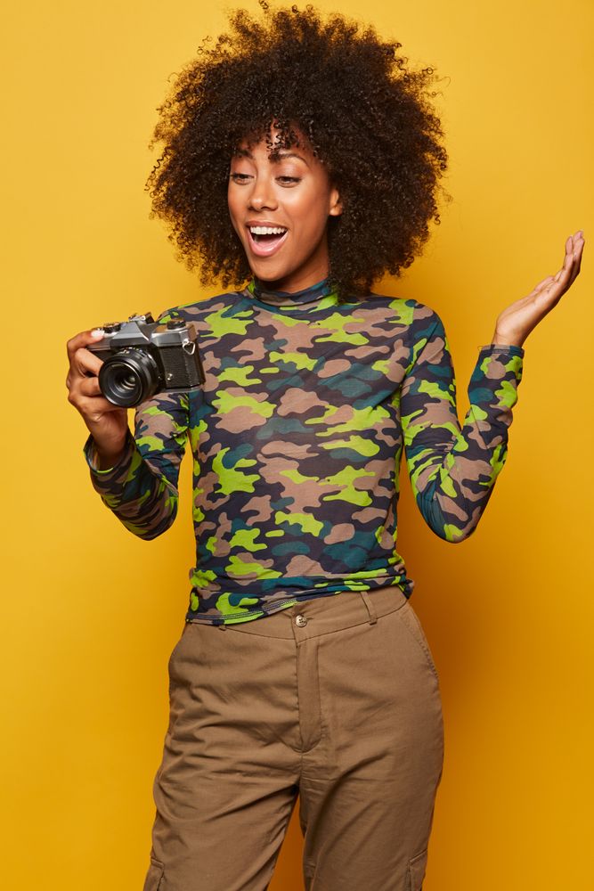 Trendy female paparazzi holding camera