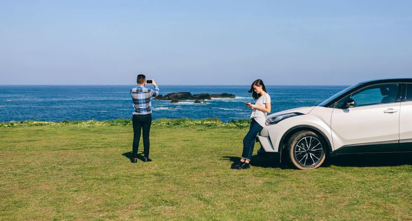 Couple traveling by car photographing the landscape