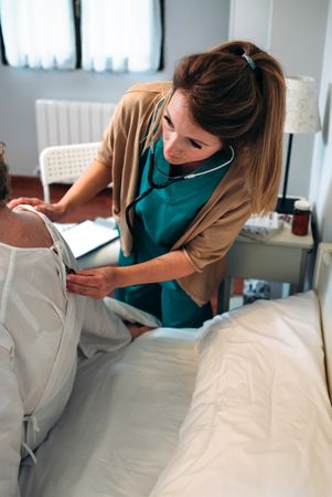 Caregiver auscultating woman