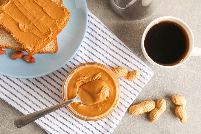 Yummy peanut butter breakfast on grey background, top view