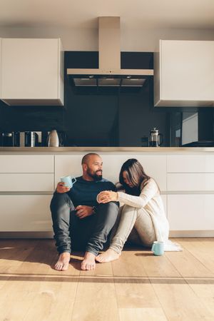 Young loving couple enjoying a coffee on kitchen floor