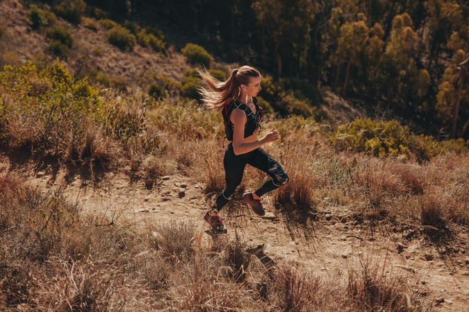 Fit young woman running on mountain trail