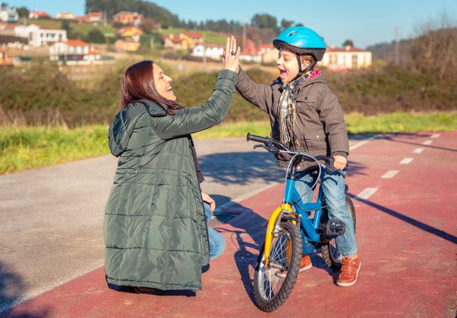 Mother and son high fiving during family bike ride