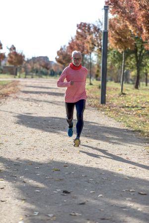 Mature man jogging outside in park