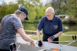 Two older people prepping boat for rowing