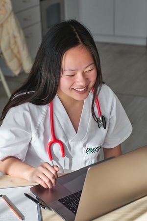 Delighted Asian doctor making video call with patient