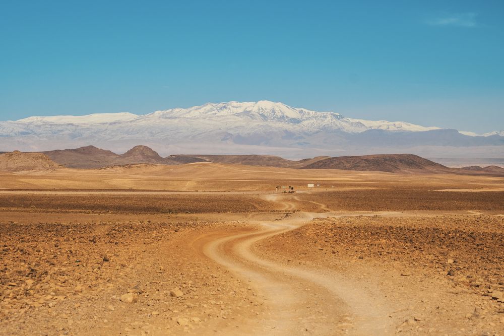 Road between desert and blue sky