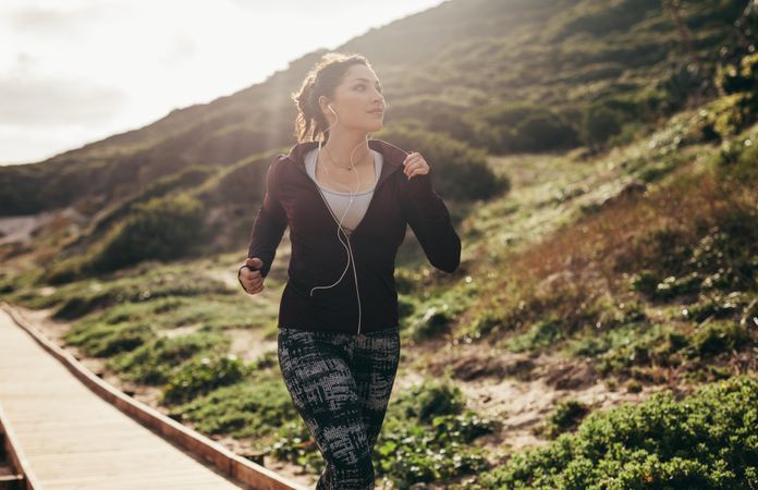 Female doing jogging exercise on path by the mountain