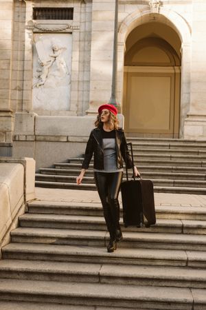 Cheerful tourist walking with suitcase