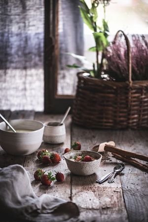 Bowl with porridge and strawberry on rustic table