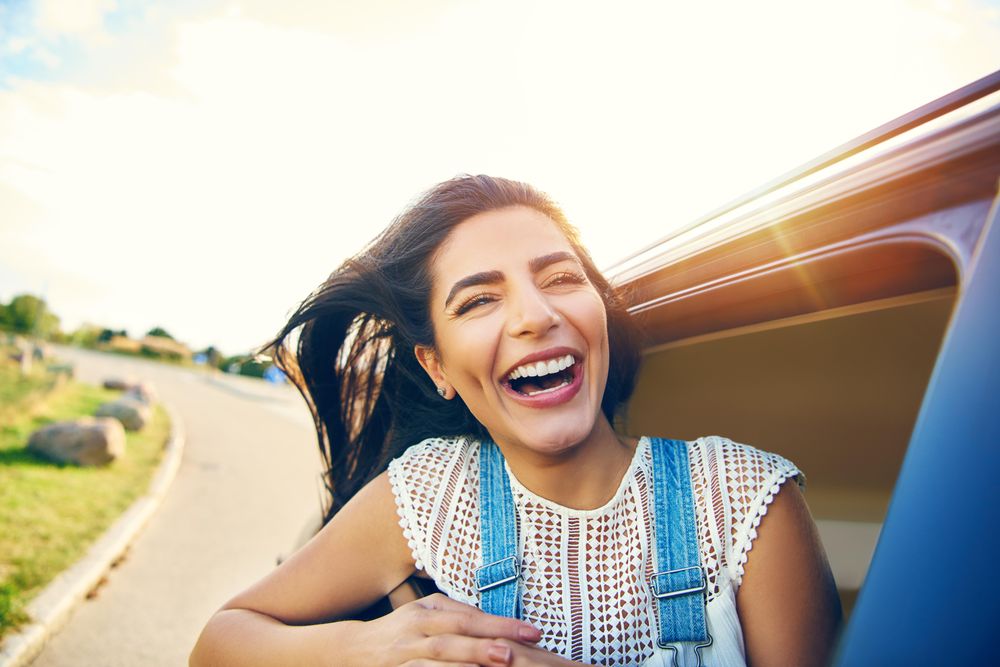 Smiling female half outside of car window